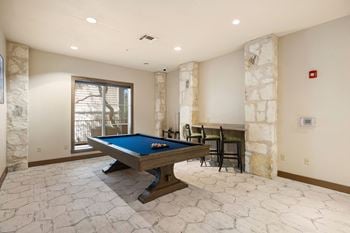 A game room with a pool table and a bar